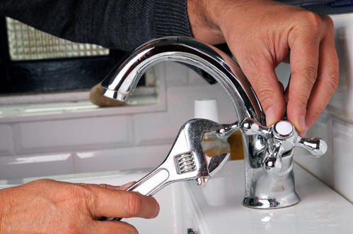 Plumber repairing the basin tap